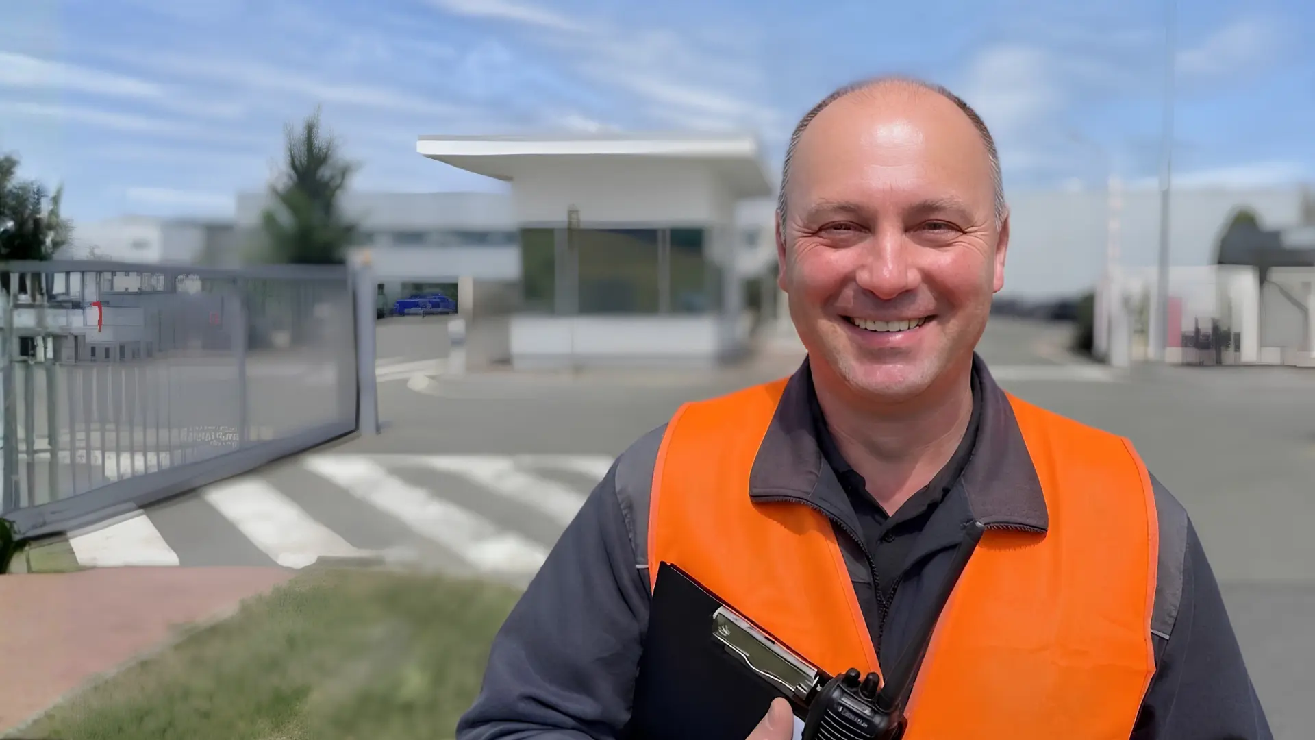 usměvavý BOZP manager/technik v reflexní vestě v areálu